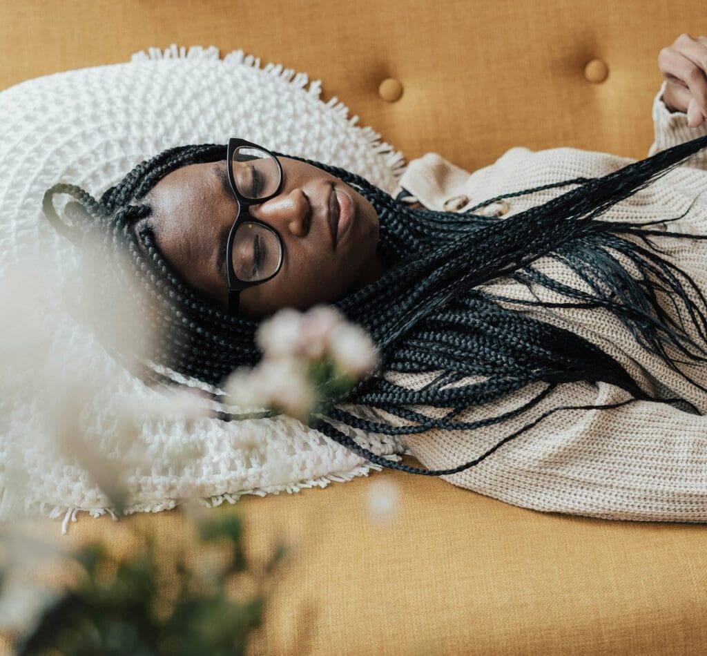 woman laying on yellow couch sleeping as part of trauma responses