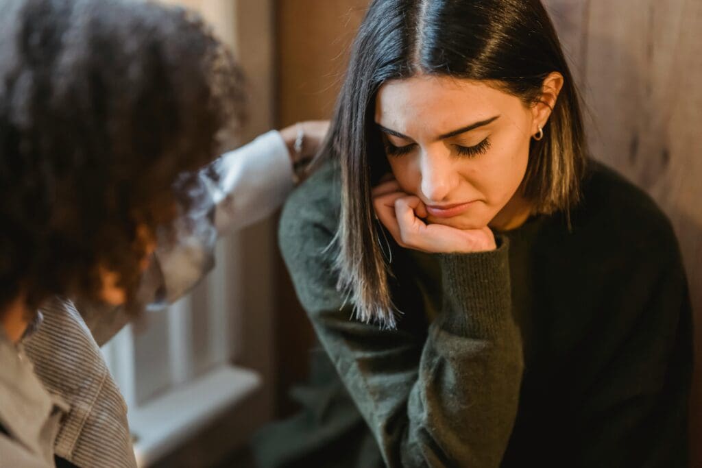 woman comforting girlfriend with difficulty making decisions anxiety